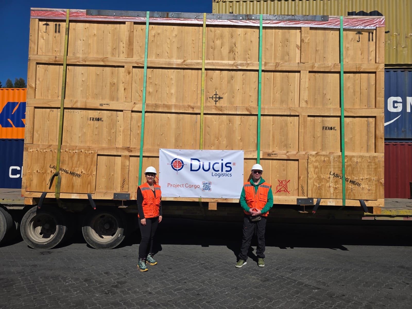 Equipo de DUCIS junto al embalaje de la planta, con el estandarte de Project Cargo